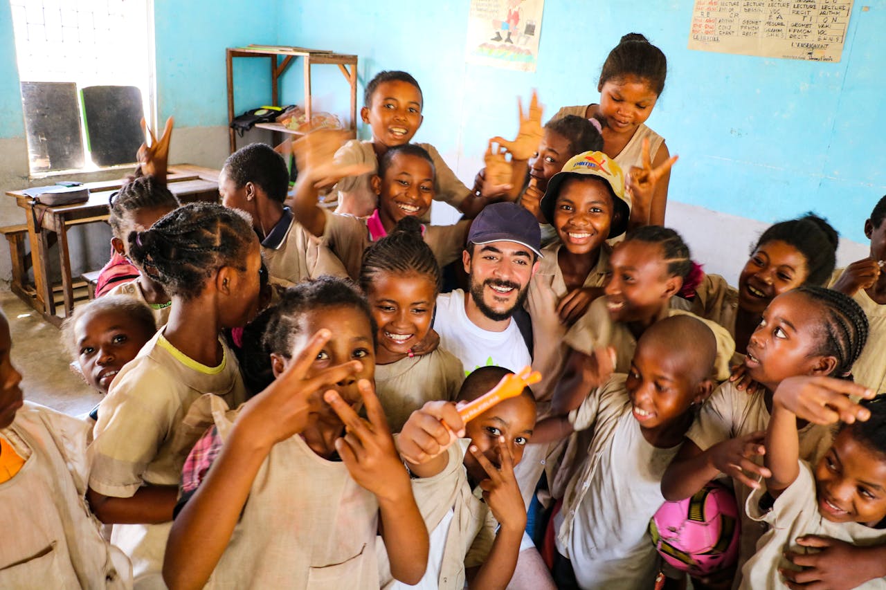 who-we-are A group of smiling students in a lively classroom setting enjoying a moment of fun and happiness.